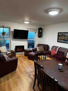 a living room with a couch and a table at River View - Modern 4 Bedroom Bungalow in Cabraghkeel