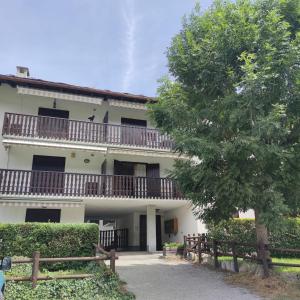 un grande edificio bianco con balconi e un albero di Sun & Relaxation La Tour a Morgex