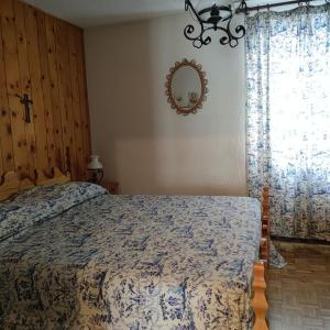 una camera da letto con un letto e uno specchio sul muro di Sun & Relaxation La Tour a Morgex Altre 5 foto