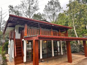 a house with a large deck and a staircase at Pears Villa Resort Haputale in Ginigatgala