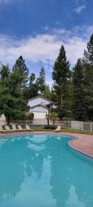 a large blue swimming pool in front of a house at Brummett Lodge in Bass Lake
