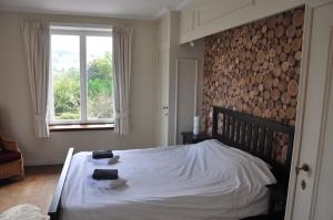 a bedroom with a large bed with a logs wall at La Délice in Érezée