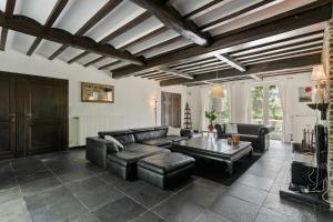 a living room with a leather couch and a table at La Délice in Érezée +2 photos