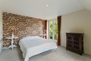 a bedroom with a bed and a wall of logs at La Délice in Érezée