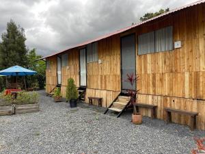 a wooden building with benches and an umbrella at Glamping en villa 2 in Villa de Leyva
