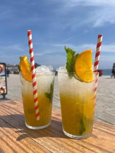 two drinks sitting on a wooden table on the beach at Blue Wave House Corralejo in La Oliva