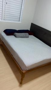 a bed sitting in a room with a window at Hospedagem de qualidade in Varginha