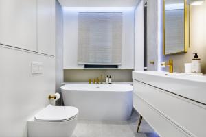 グディニャにあるPlac Unii Lux - Comfy Apartmentsのトイレと洗面台を備えた白いバスルーム