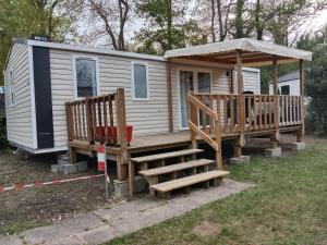 a tiny house with a porch and a gazebo at Mobile home SUPER CORDELIA CONFORT & FAMILIAL in Pont-Aven