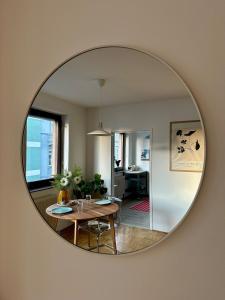 a mirror reflecting a room with a table and a dining room at Zentrale Wohnung mit Parkplatz in Graz