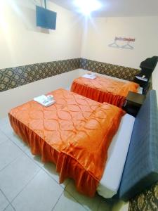 Samay Misti ApartHostal في أريكيبا: سريرين مع أغطية برتقالية في الغرفة