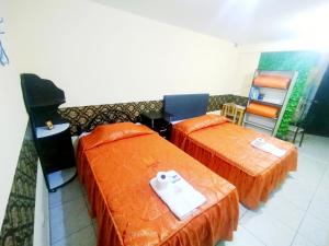 Samay Misti ApartHostal في أريكيبا: سريرين مع أغطية برتقالية في الغرفة