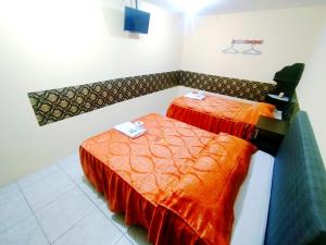 Samay Misti ApartHostal في أريكيبا: غرفة بسريرين وملاءات برتقالية