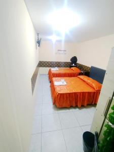 Samay Misti ApartHostal في أريكيبا: غرفة بسريرين وملاءات برتقالية