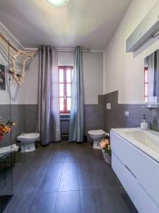 y baño con 2 aseos, bañera y lavamanos. en Nest Guesthouse, en Castelnuovo del Garda 25 fotos más