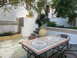 a table and chairs with a vase on a patio at Mytilini Townhouse in Mytilene