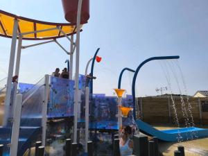 a girl is standing in a water park at Mobilhome Metanova in Camiers