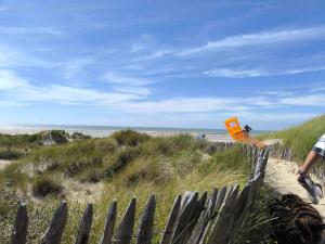 a person is flying a kite on the beach at Mobilhome Metanova in Camiers