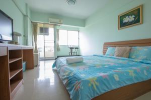 a bedroom with a bed with a blue comforter at The Garden Place Bangkok in Nonthaburi
