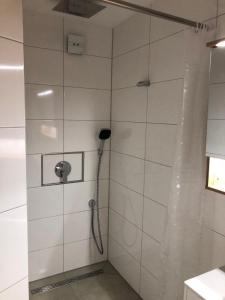 a shower with a hose in a white tiled bathroom at Neu saniert, 7 Personen, direkt an der Autobahn und Mercedes Werk in Sindelfingen +9 photos