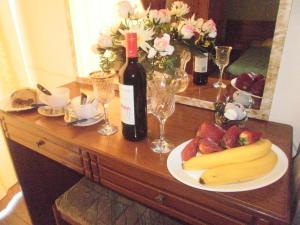 a table with a plate of fruit and a bottle of wine at Tassos Apartments in Faliraki