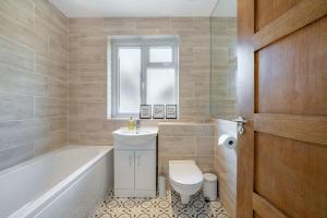 a bathroom with a toilet and a sink and a tub at Luxury Tottenham Stadium Retreat - 2 minute walk to stadium in London
