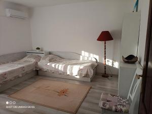 a bedroom with two beds and a rug on the floor at Къща за гости НИКА in Kavarna