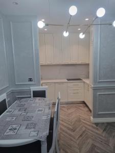 a kitchen with a table and white cabinets and a table and chairs at Kodra e diellit residence 2 in Selitë e Vogël