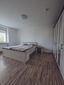 ein Schlafzimmer mit einem Bett und einem Holzboden in der Unterkunft Ferienwohnung im Tal der Liebe in Schmelz