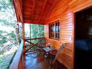 a cabin with two chairs and a table on a porch at Chalet del lago Don Asterio in Ciudad del Este