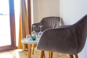two chairs and a table with wine glasses and a tablences at Villa Purić in Rovinj