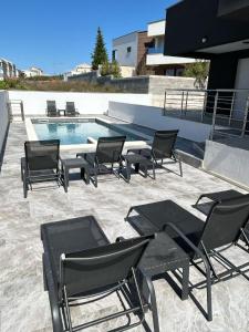 un gruppo di sedie sedute accanto a una piscina di Luna Deluxe a Novalja (Novaglia)