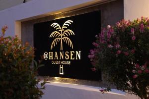a sign for a guest house with a palm tree at Hansen Guest House in Piet Retief