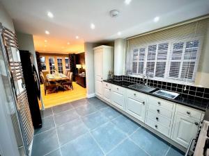 a kitchen with a sink and a table in it at Honey Hill Cottage - 4 Bedroom Detached House in Cambridge