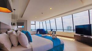 a bedroom with a large bed and a flat screen tv at Navio Hotel in Manta
