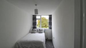 a white bedroom with a bed with a window at Entire House Hertfordshire in Hatfield +12 photos