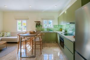 una cucina con mobili verdi, tavolo e sedie di Aloni Estate Corfu ad Acharavi