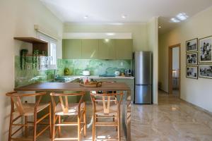 una cucina con isola di cucina, sedie e frigorifero di Aloni Estate Corfu ad Acharavi