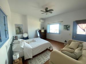 a bedroom with a bed and a ceiling fan at L' Atelier, Marpissa Paros in Márpissa