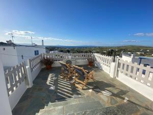 a patio with two chairs on the roof of a house at L' Atelier, Marpissa Paros in Márpissa