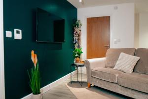 a living room with a couch and a television at Firdaus Westgate 5 in Huddersfield