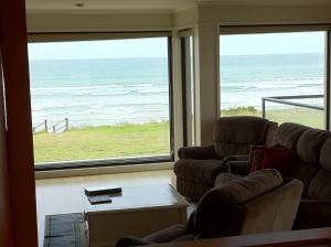 a living room with two couches and a view of the ocean at Boathouse Holiday House in Port Fairy