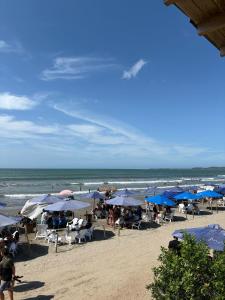 - une plage avec des parasols et des chaises bleus et l'océan dans l'établissement Apartamento Descanso Cartagena, à Manzanillo del Mar