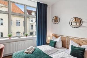 a bedroom with a bed and a large window at NEU Altstadtliebe - gemütliche Apartments in der historischen Altstadt, zentral und komfortabel in Wismar