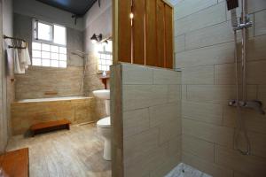 La salle de bains est pourvue d'une douche, de toilettes et d'une baignoire. dans l'établissement Ttdropin Homestay, à Taïtung