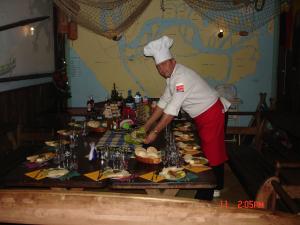 um chef em pé em frente a uma mesa com comida em Marina Karsibór em Karsibór