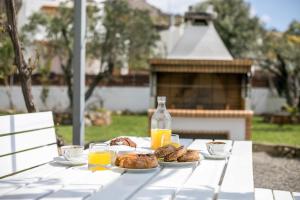 a white table with breakfast foods and orange juice at Ennisfree Villa in Kiotari