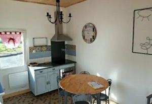a kitchen with a table and a stove top oven at Néflier in Ménesplet
