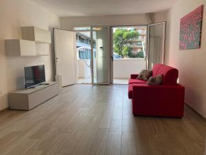 a living room with a red couch and a television at Le Casine di Cervia in Cervia +61 photos