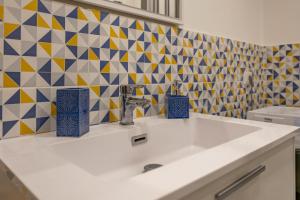 a bathroom with a sink and a tile wall at Impero 5 duepiuno in Acquaviva delle Fonti +17 photos